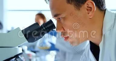 4k实验室使用显微镜的男科学家